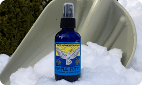 A bottle of purple puffed is sitting in the snow.